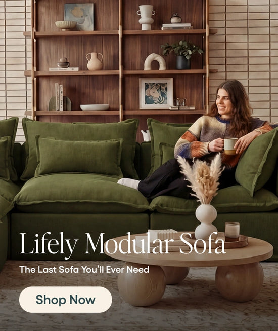 Woman sitting on a green modular sofa in a living room with wooden shelves and decor.