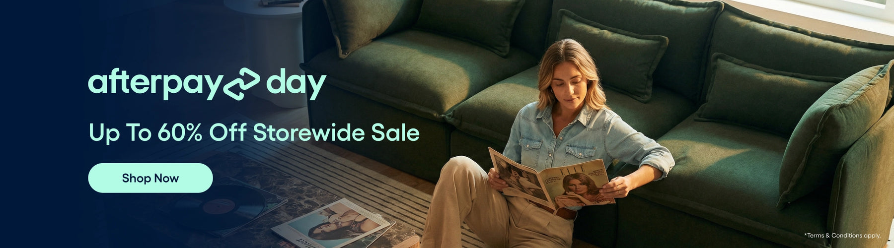 Woman reading a magazine on a green couch with 'afterpay day' sale text overlay.