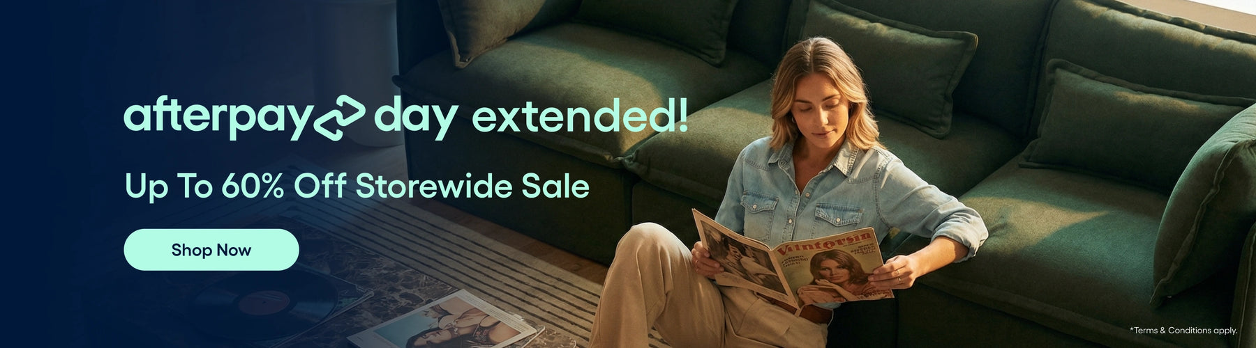 Woman reading a newspaper on a green couch with promotional text about an extended Afterpay Day sale.