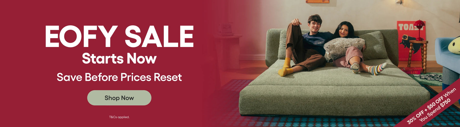 Two people sitting on a couch with a promotional banner for an EOFY sale on a red background.