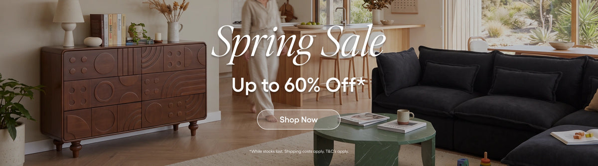 A promotional banner for a spring sale featuring a large black sectional sofa, a dark wood credenza, and a green coffee table in a modern living room setting, with text overlays reading 'Spring Sale Up to 60% Off' and 'Shop Now'.