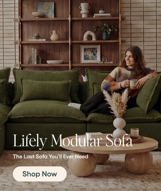 Woman sitting on a green modular sofa with a coffee table and bookshelf in the background.