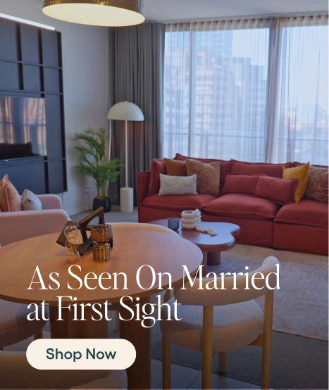 Modern living room with red sofa, wooden coffee table, and large windows.