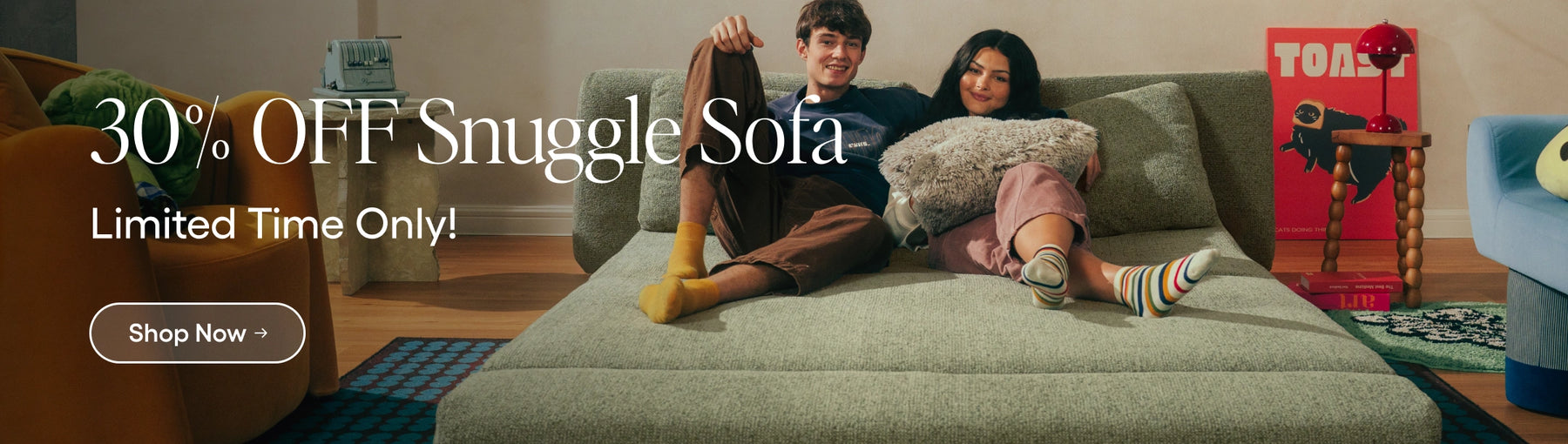 Two people sitting on a Snuggle Sofa with promotional text overlay.